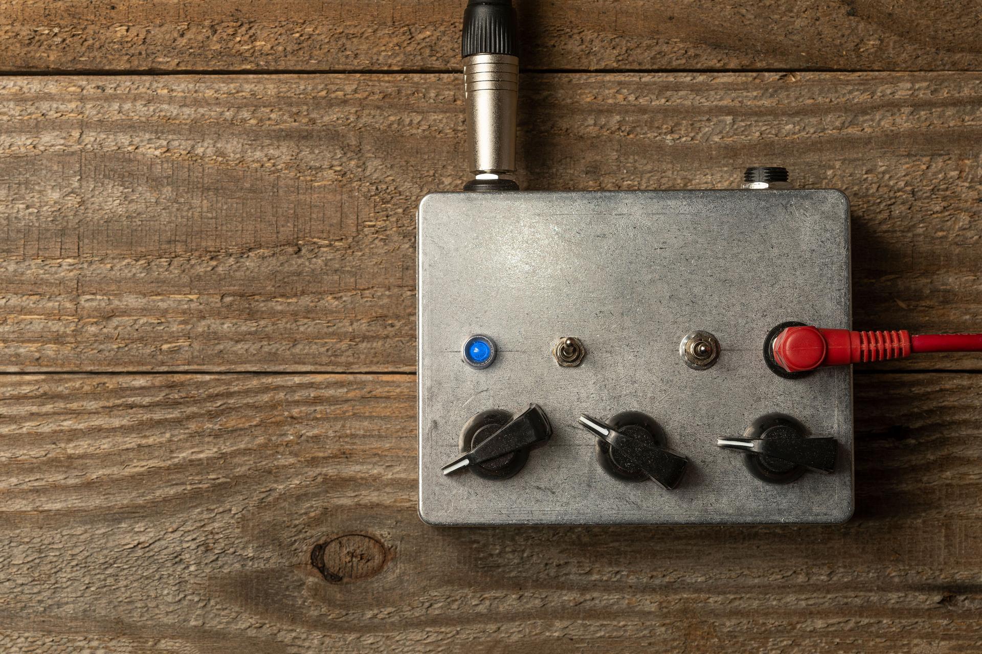 Metal guitar pedal amplifier on wooden floor